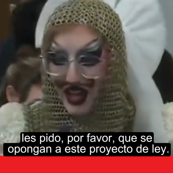 Drag performer on stage with family audience in the background