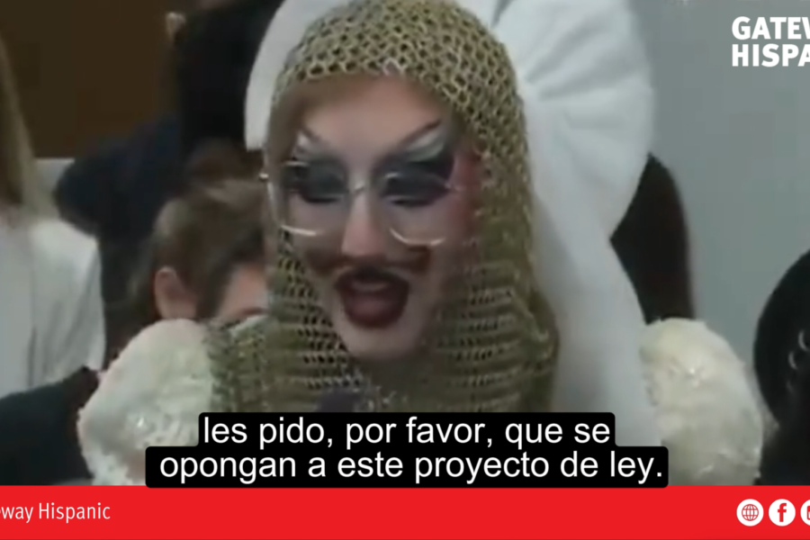 Drag performer on stage with family audience in the background